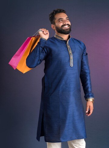indian-traditional-young-handsome-man-holding-posing-with-shopping-bags-dark-background_136354-15268